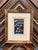 Framed antique Halloween postcard featuring vintage holiday imagery in a decorative frame.