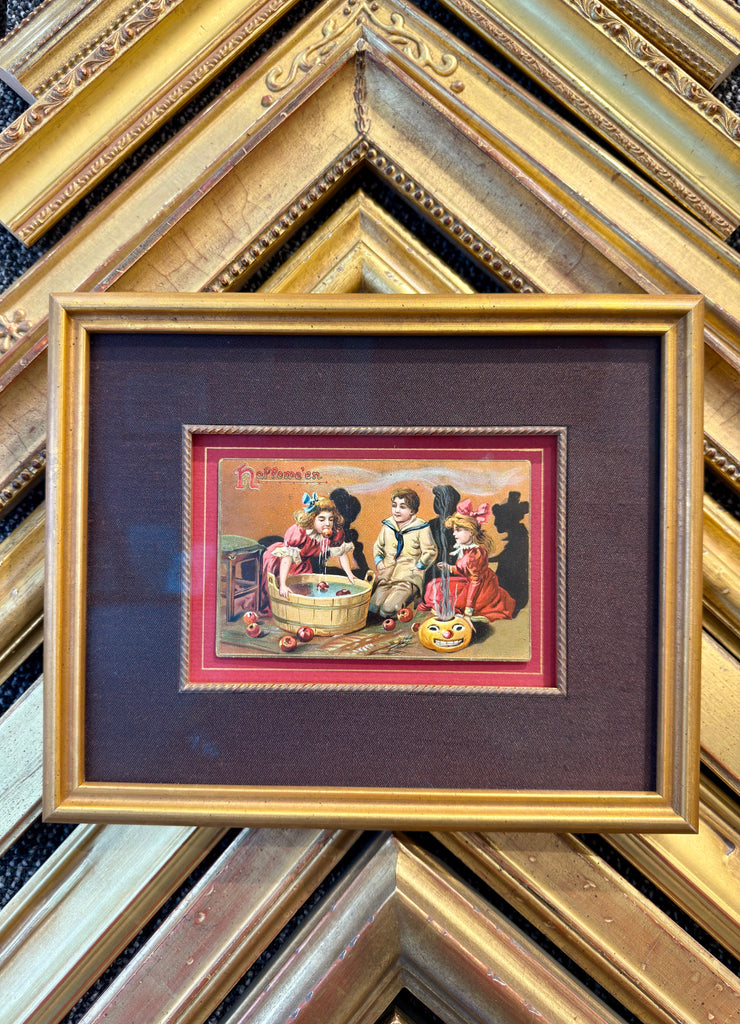 Framed antique Halloween postcard featuring vintage holiday imagery in a decorative frame.